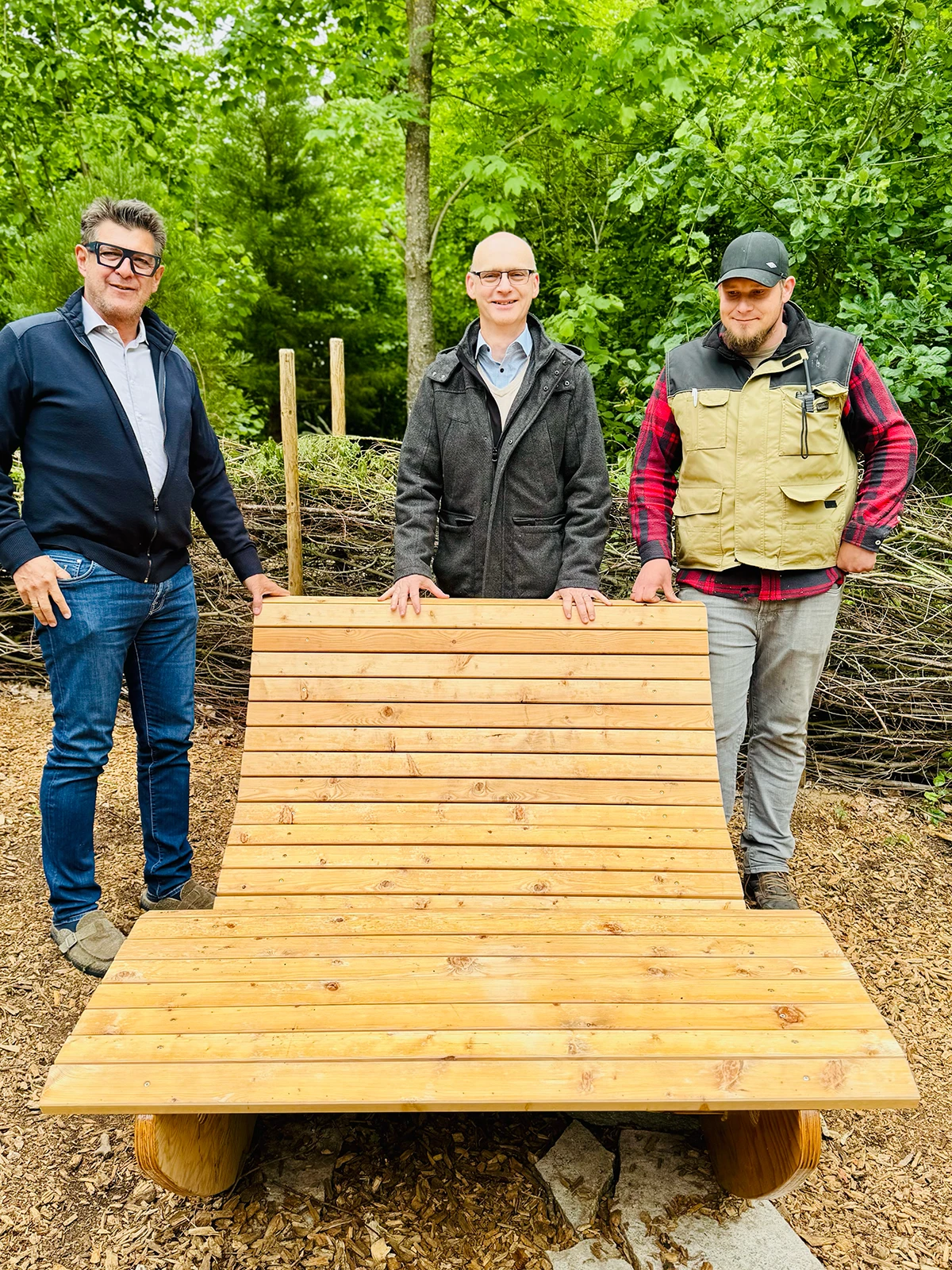 Tobias Popp zeigt Markus Bammes und Peter Nußbaumer die neuen Relaxliegen