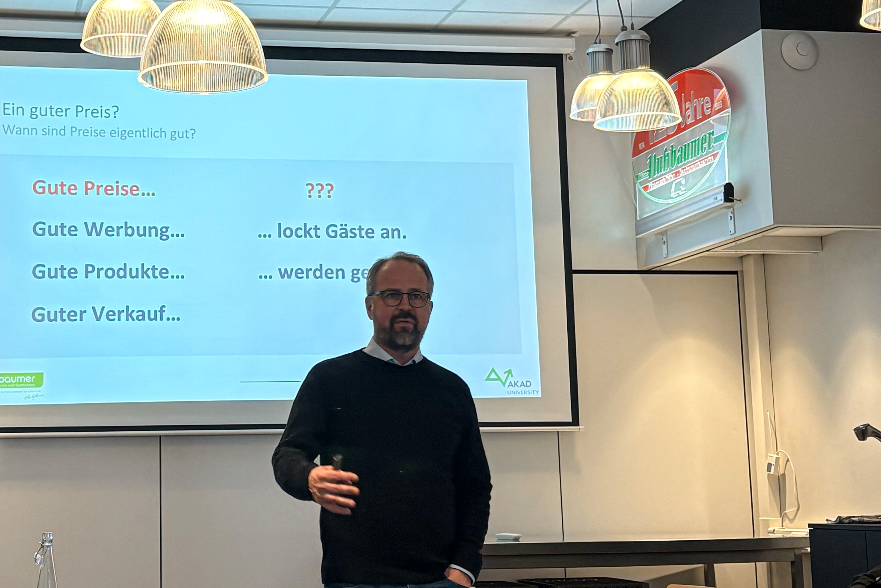 Ein Mann steht vor einer Projektionsleinwand.