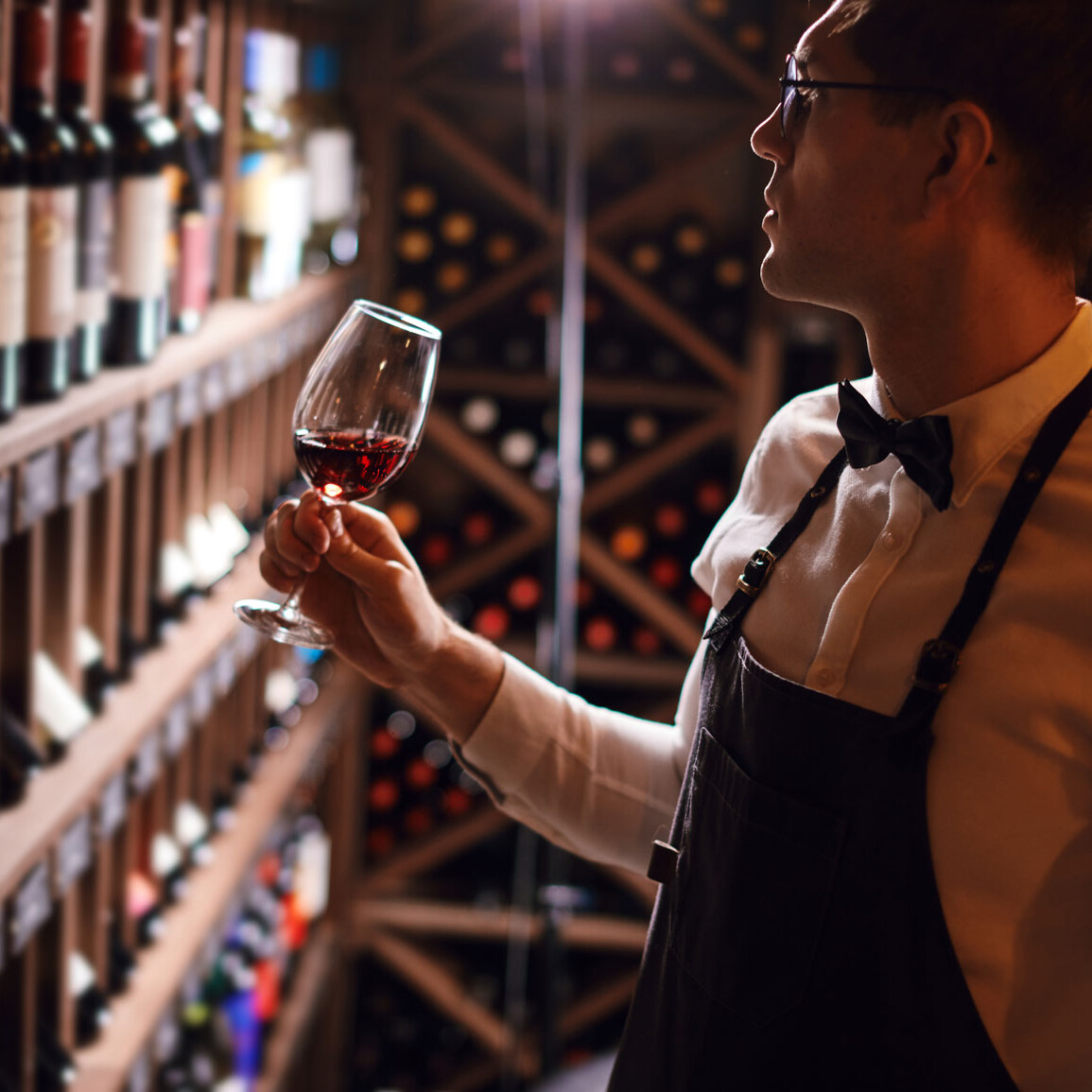 Ein Mann hält ein Glas Wein.