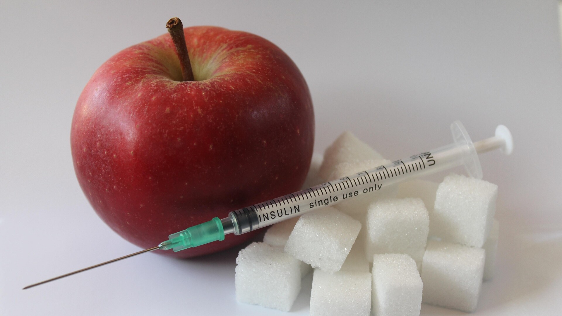 Apfel mit Spritze und Zuckerwürfel