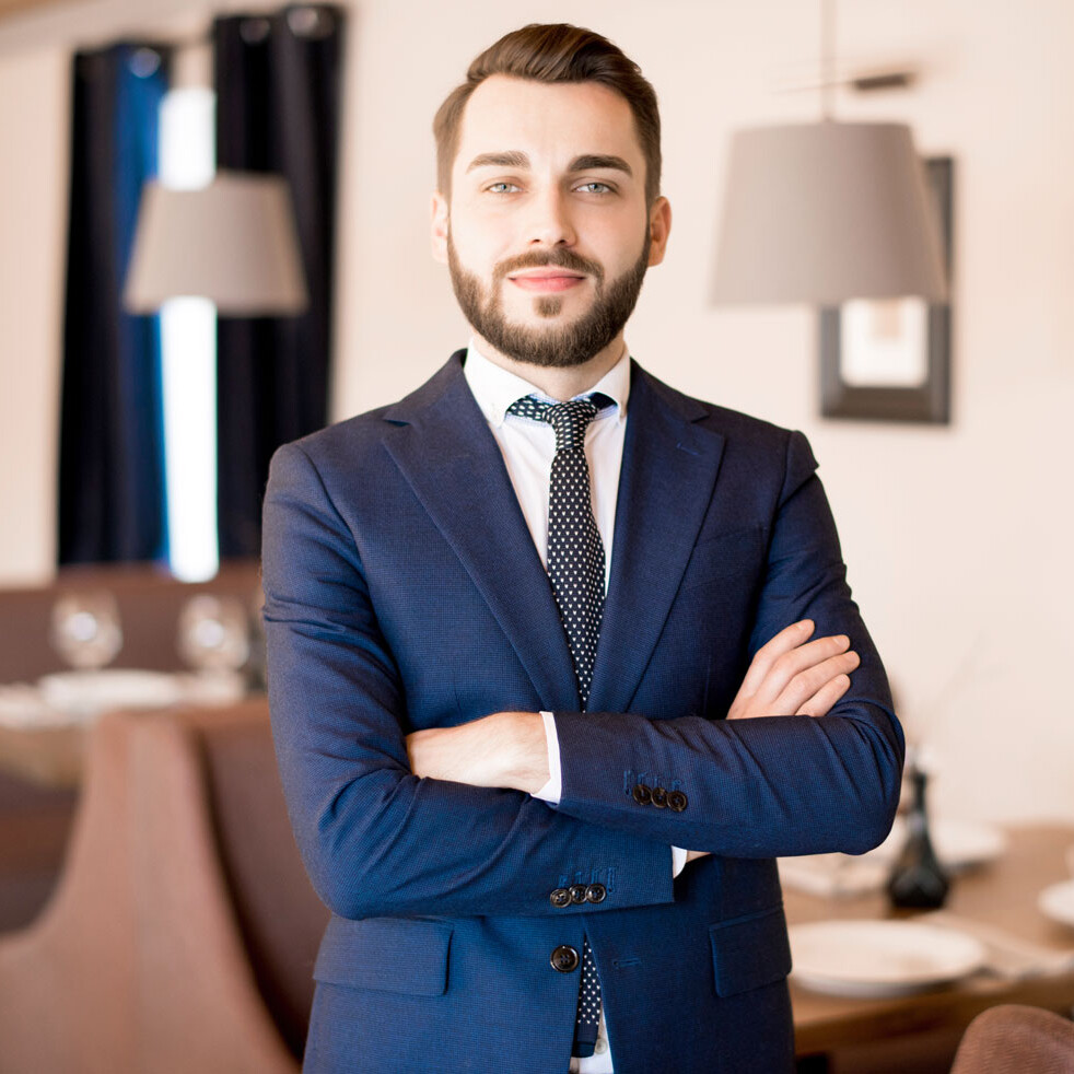 Service Workshop Servicegott Ein Mann in Anzug mit verschränkten Armen.