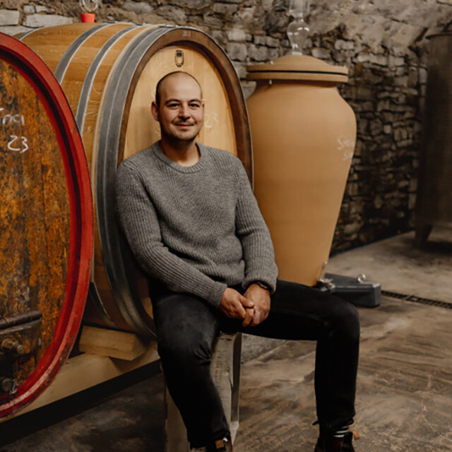 Ein Mann sitzt auf einem Fass.