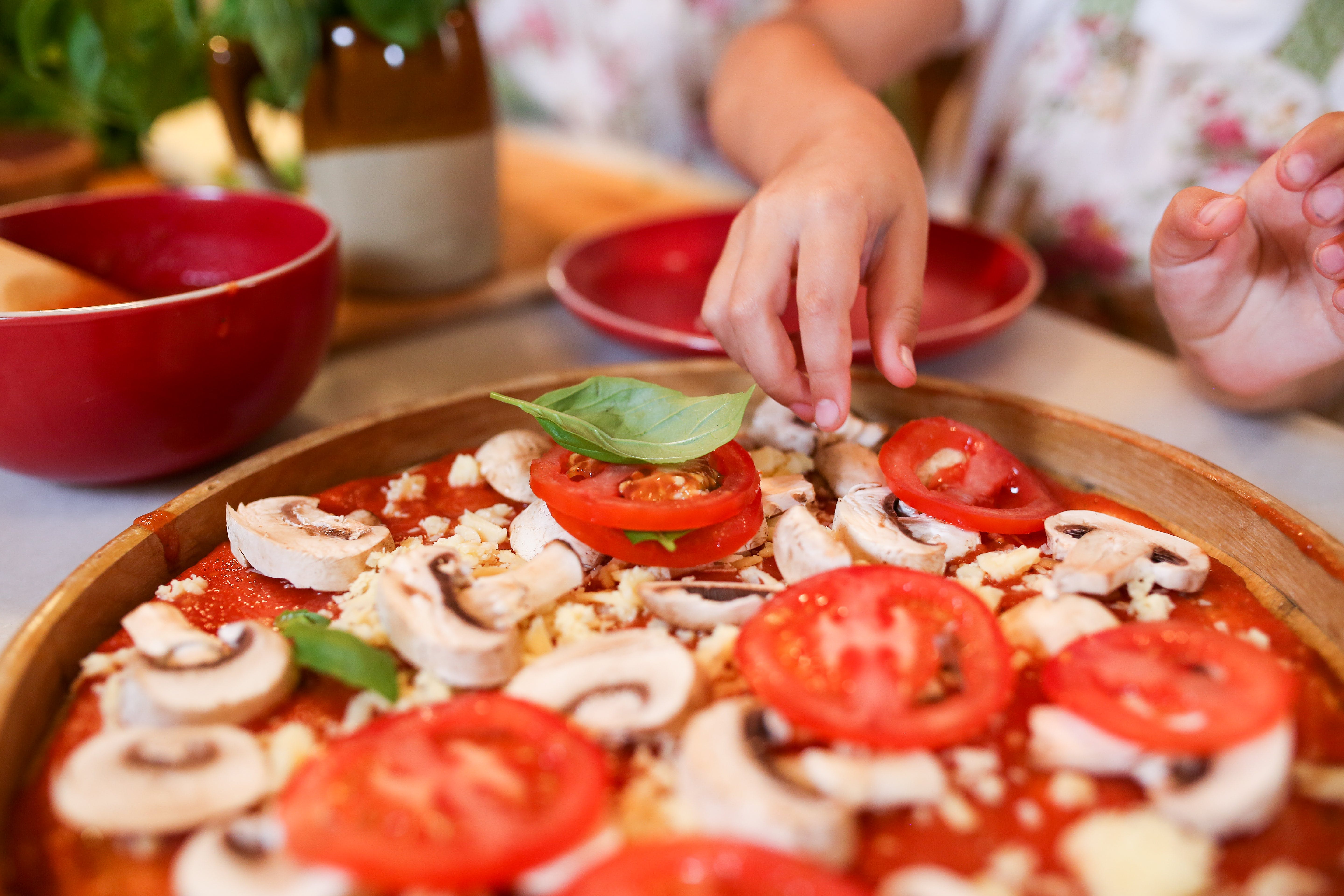 Pizza Eine Pizza mit Tomaten und Pilzen auf einem Teller.