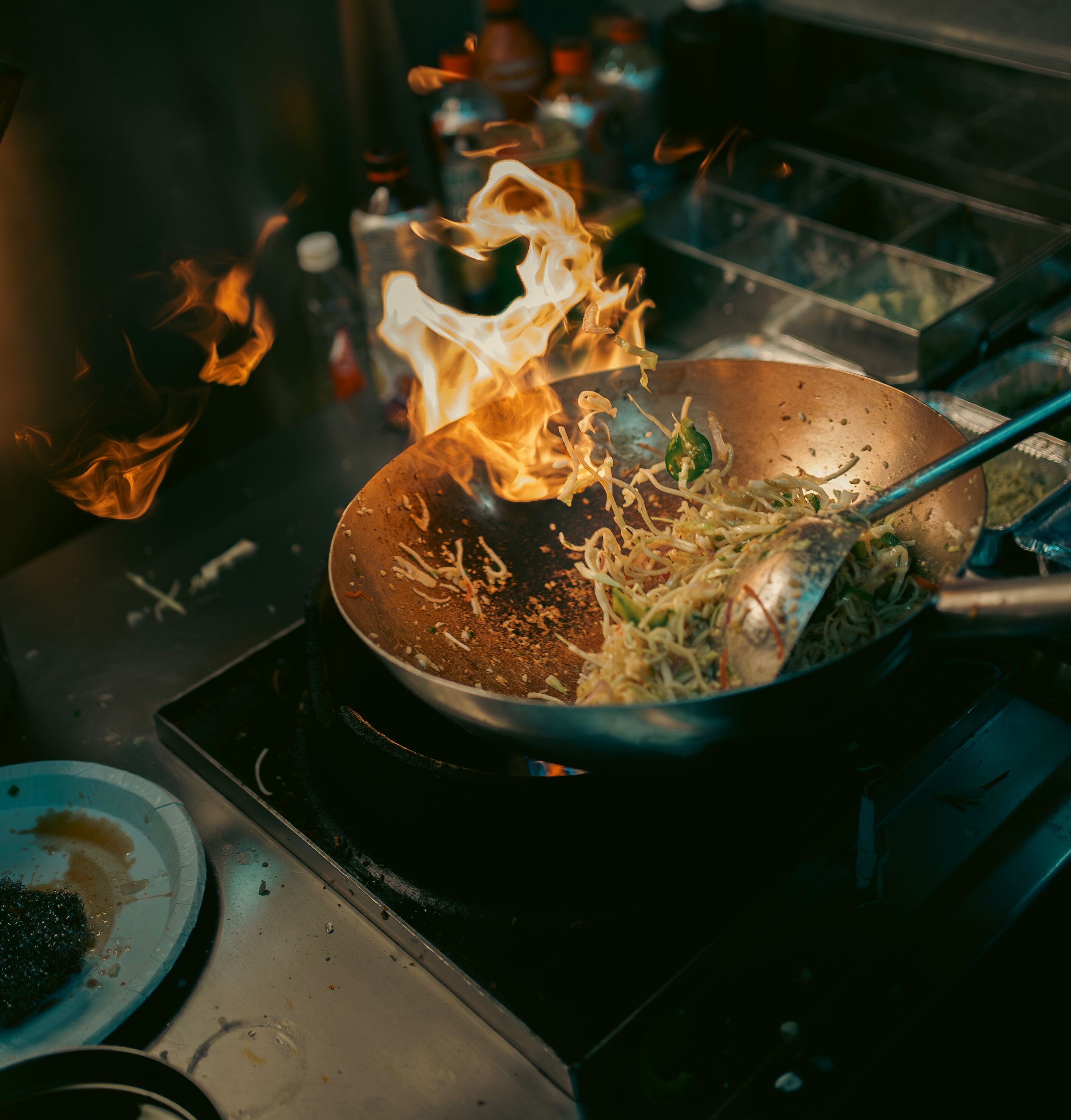Ein Wok mit brennenden Nudeln.