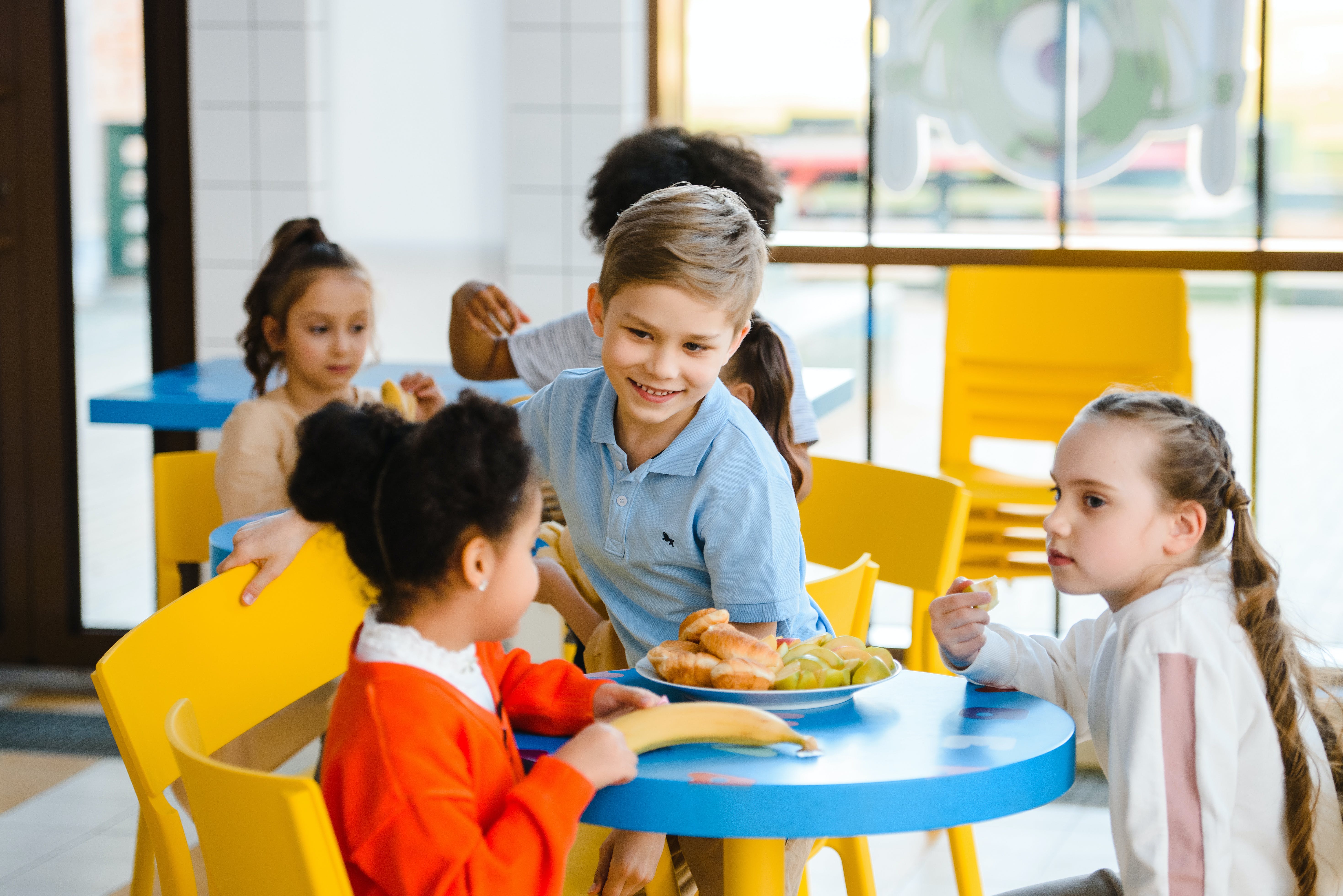 Kinder beim essen Eine Gruppe von Kindern sitzt an einem Tisch.