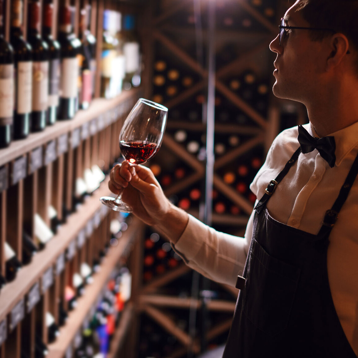 Ein Mann hält ein Glas Wein.