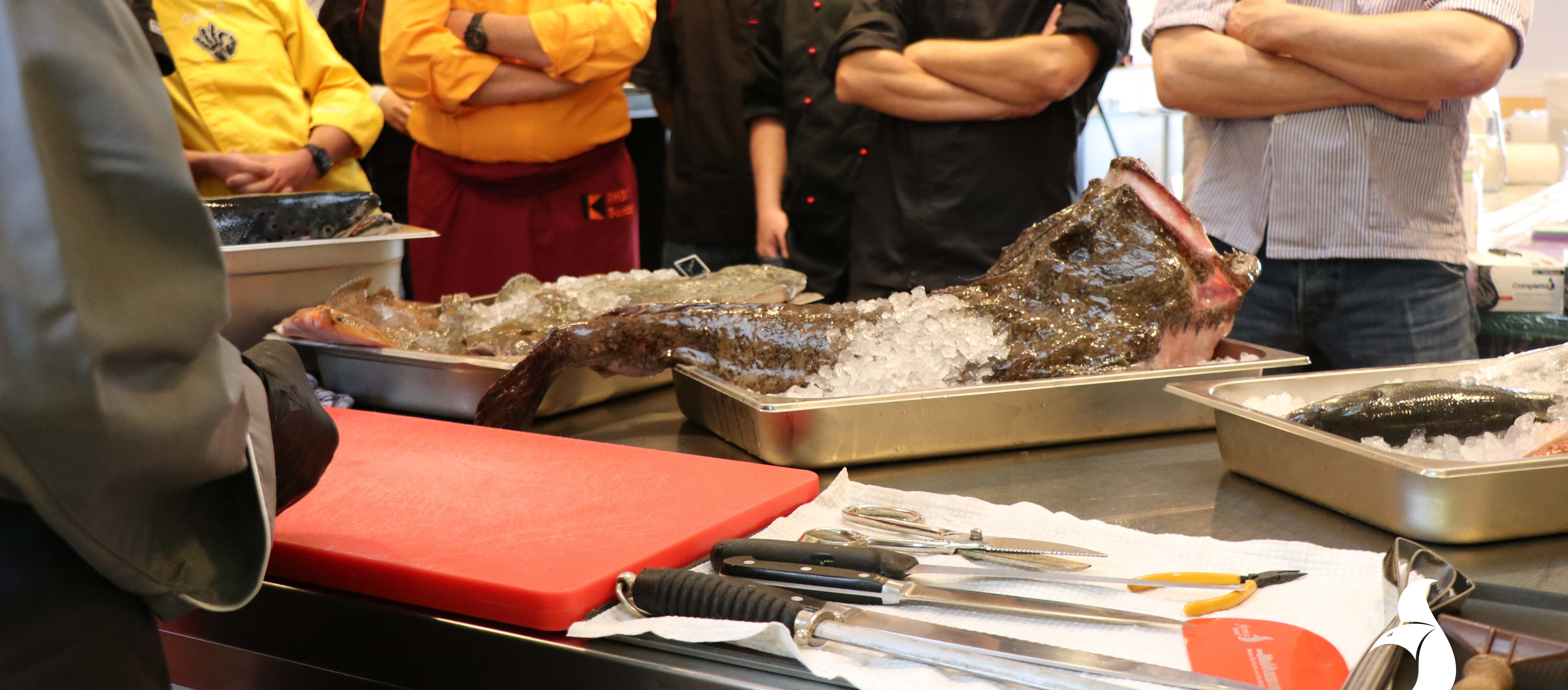 Workshop-Teilnehmer stehen um Fisch-Theke