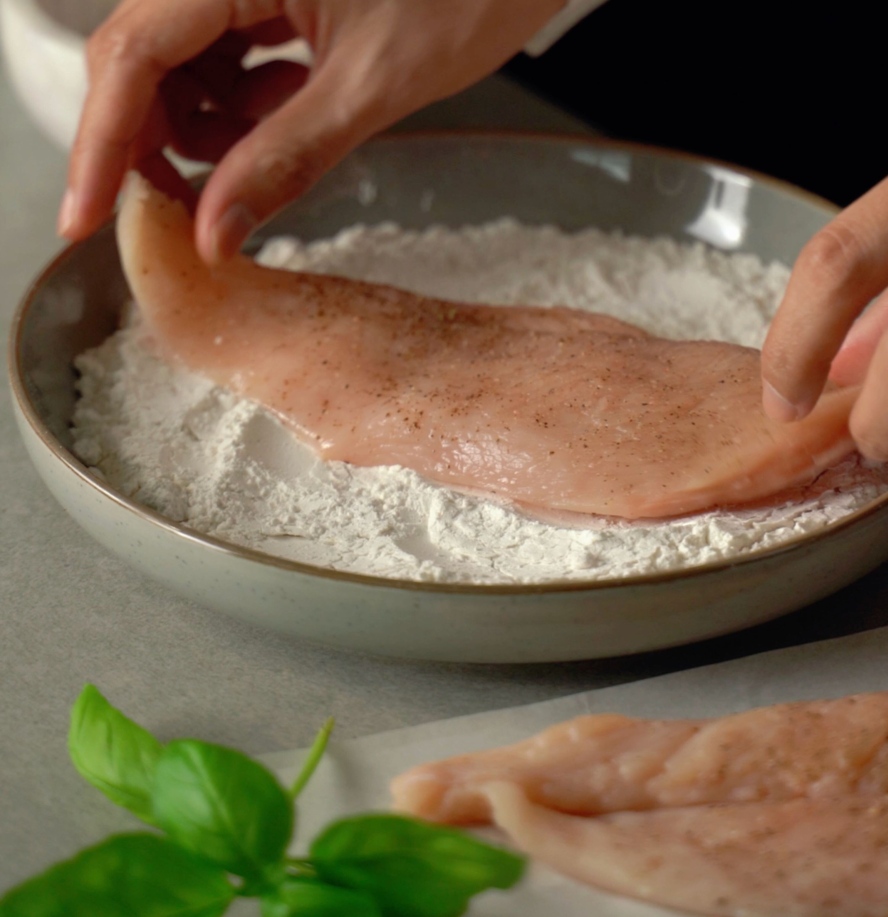 Hände einer Person, die ein Stück Fleisch halten