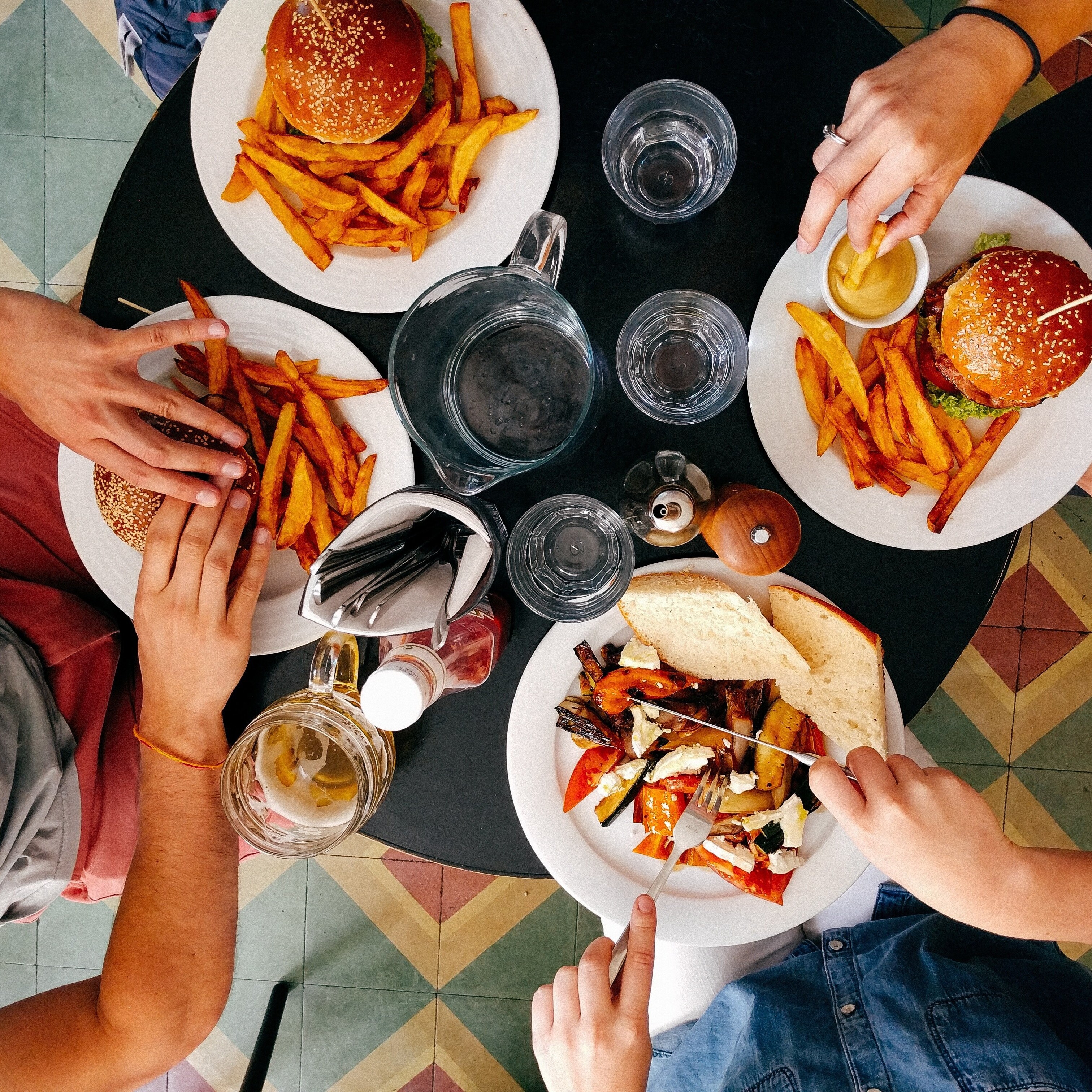 Eine Gruppe von Menschen sitzt an Tischen in einem Restaurant Eine Gruppe von Menschen isst gemeinsam an einem Tisch.