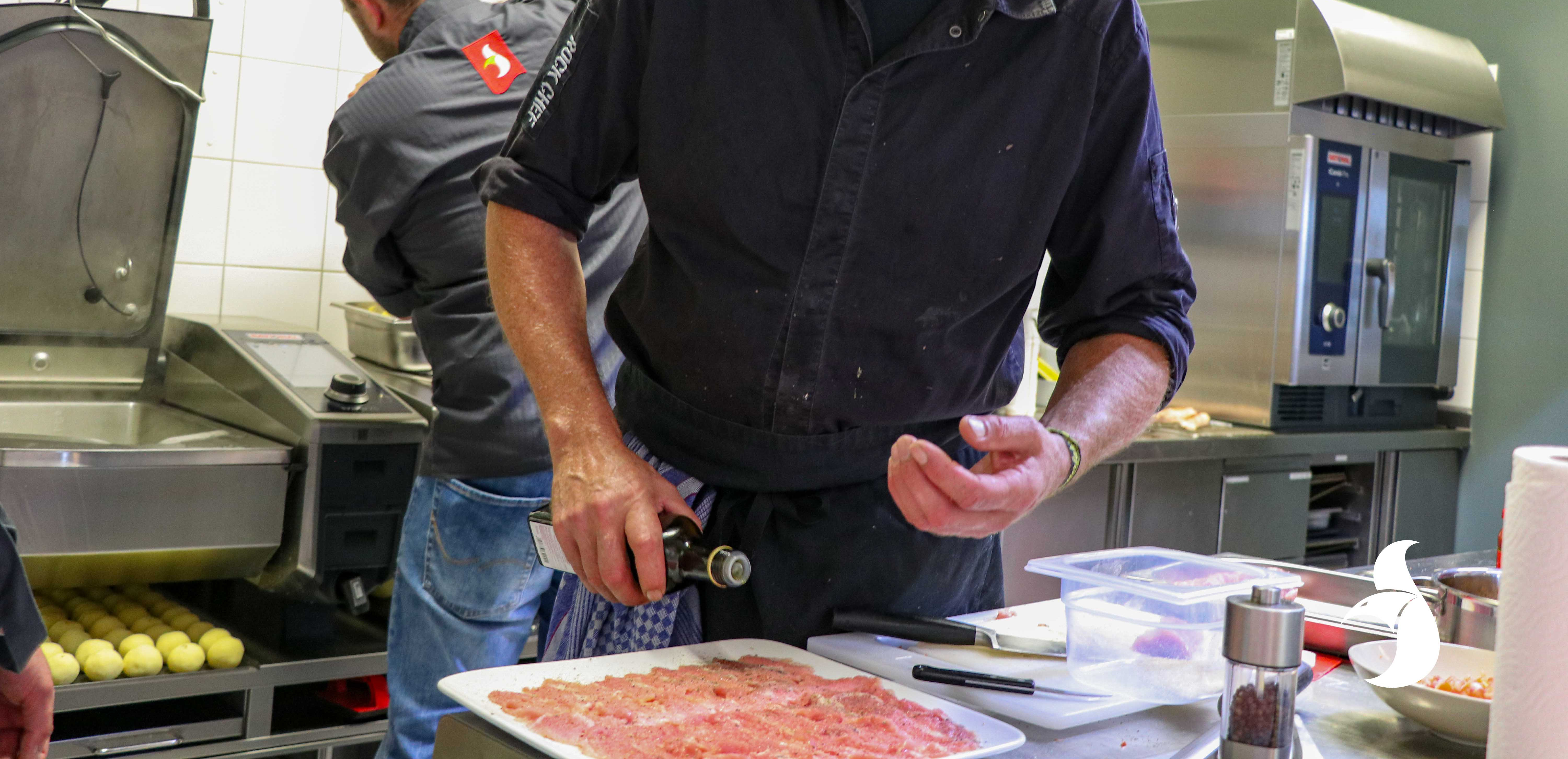 Workshop-Teilnehmer gießt Öl auf das Fleisch