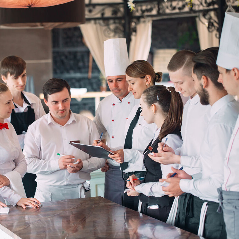 Service Workshop Anfänger Eine Gruppe von Menschen in Uniform steht um einen Tresen.