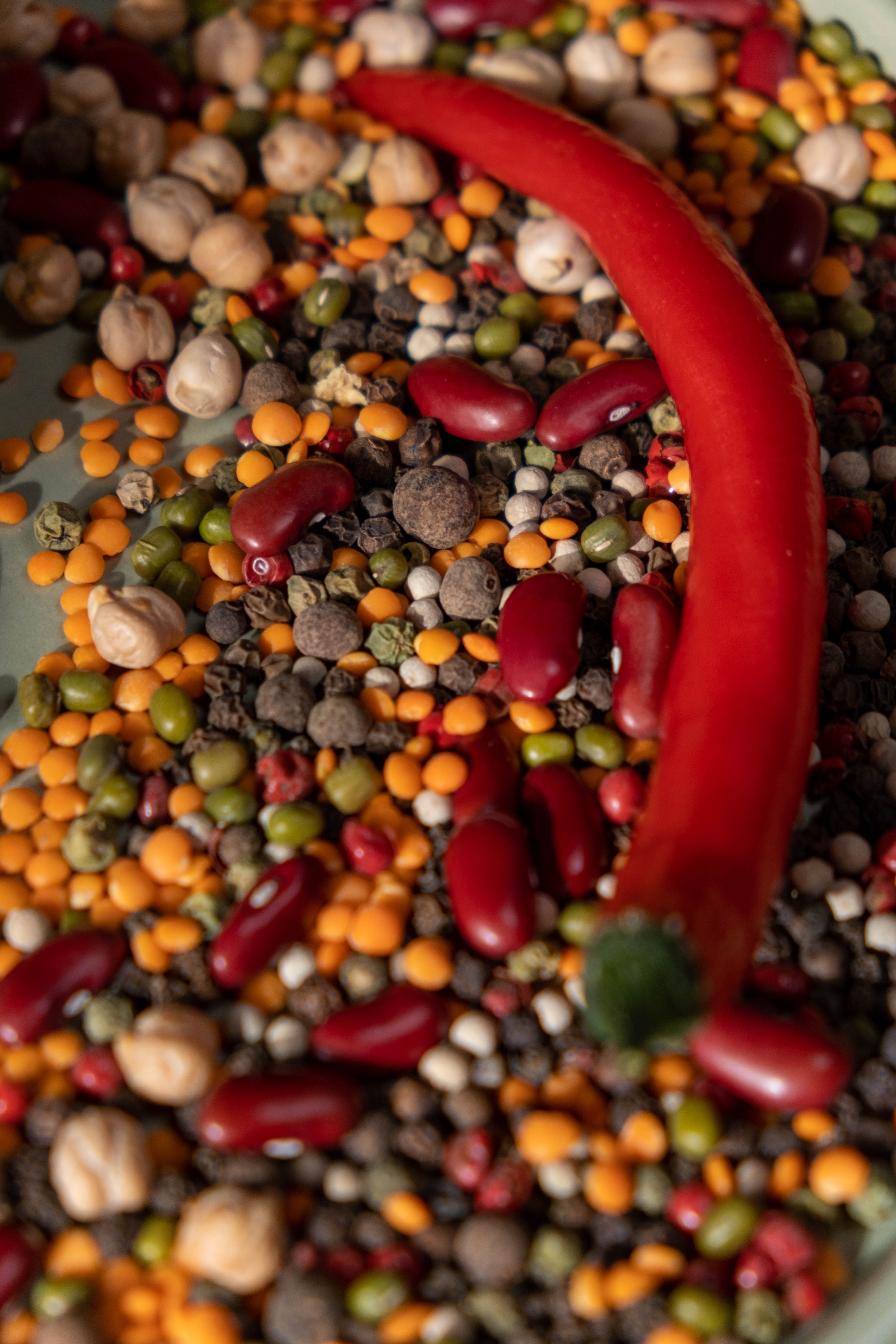 Rote Paprika neben einem Haufen Bohnen