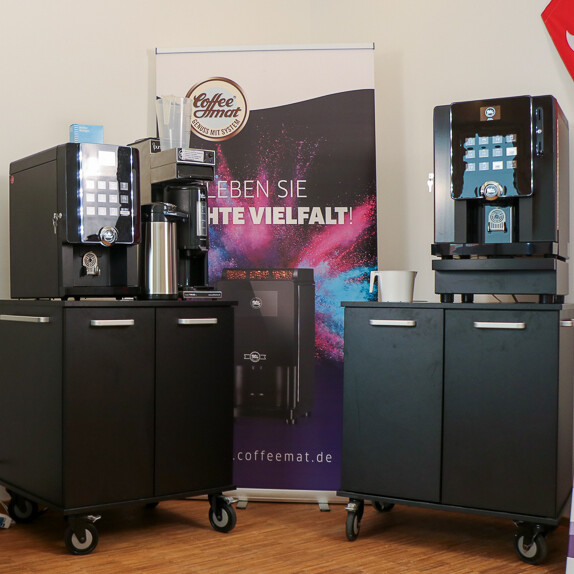 Kaffeemaschine neben einem Schild in einem Innenraum Kaffeemaschine neben einem Schild in einem Innenraum